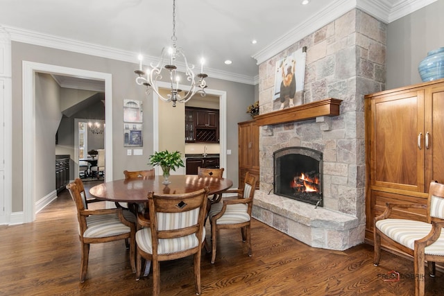 dining area with a stone fireplace, wood-type flooring, sink, a chandelier, and crown molding