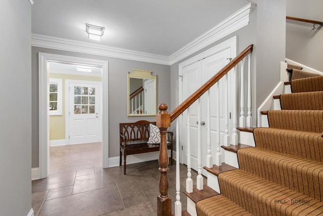 entrance foyer featuring ornamental molding and tile patterned floors