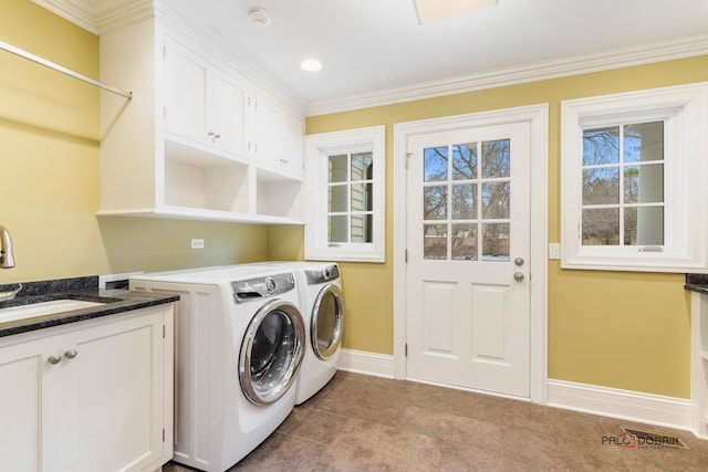 washroom featuring sink, ornamental molding, cabinets, and independent washer and dryer