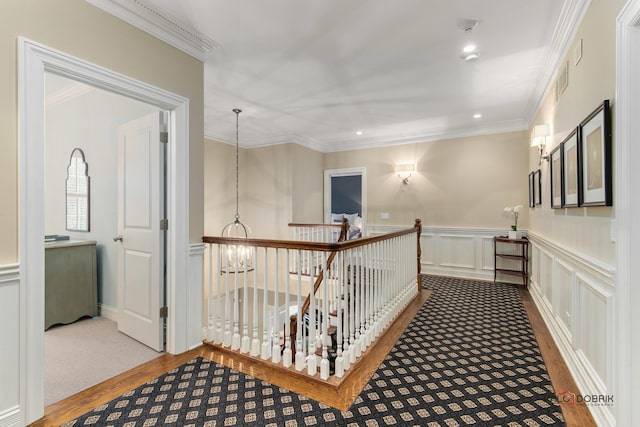 corridor featuring hardwood / wood-style flooring, crown molding, and an inviting chandelier