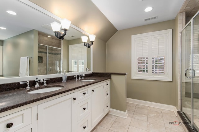 bathroom featuring tile patterned flooring, vanity, a wealth of natural light, and a shower with shower door