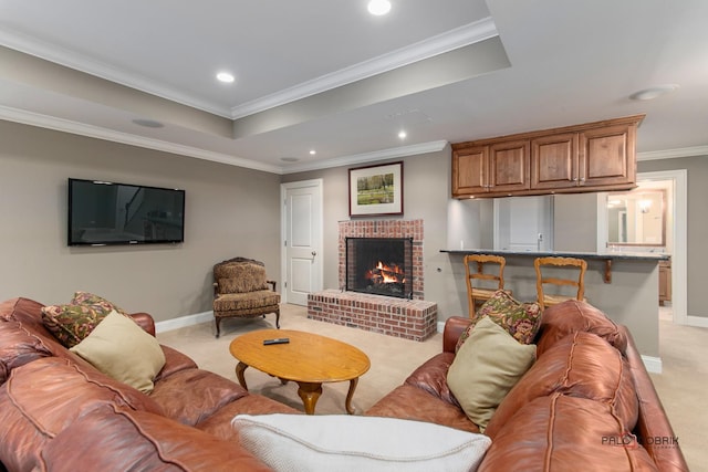 carpeted living room featuring crown molding, a brick fireplace, and a tray ceiling