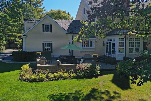 back of house with a yard and a patio