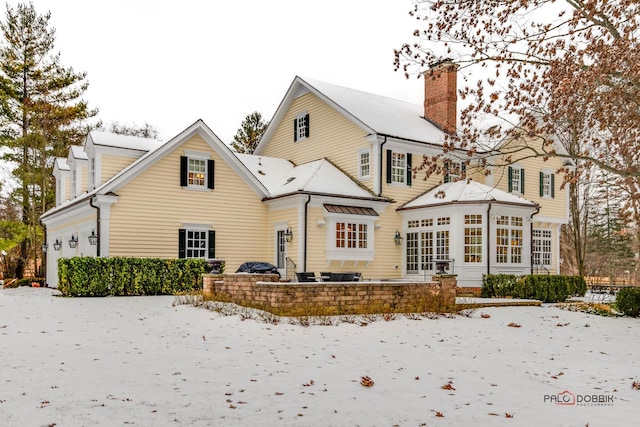 view of snow covered back of property