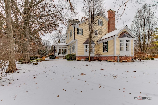 view of snow covered back of property