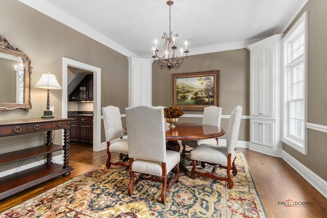 dining room featuring crown molding, dark hardwood / wood-style floors, and a notable chandelier