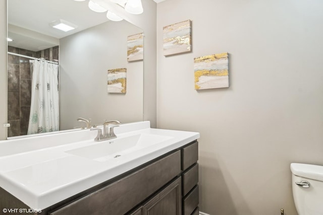 bathroom featuring toilet, vanity, and walk in shower