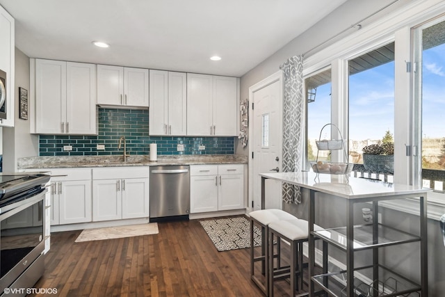 kitchen featuring white cabinets, a kitchen bar, and stainless steel appliances