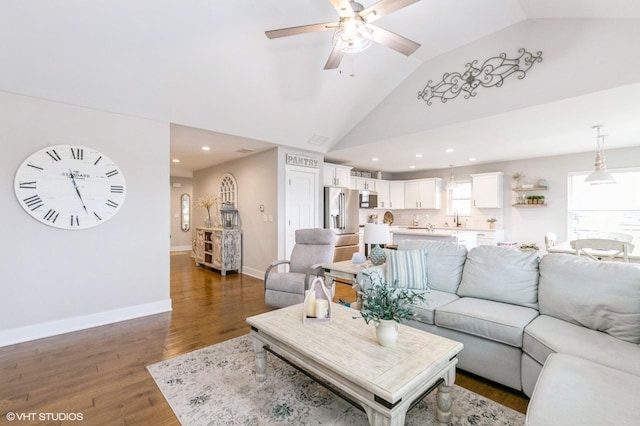 living room with ceiling fan, dark hardwood / wood-style flooring, vaulted ceiling, and sink