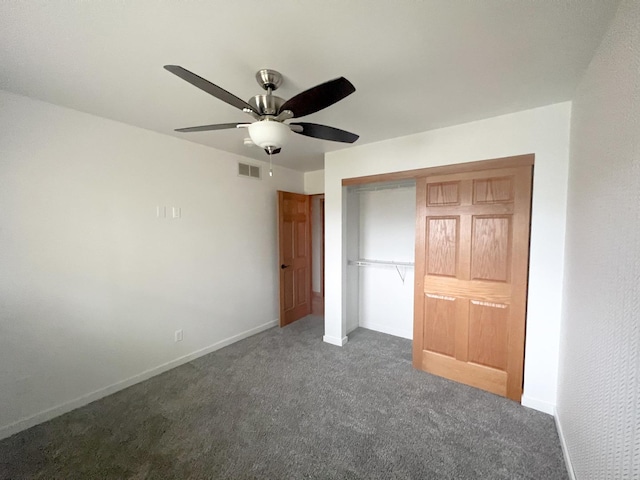 unfurnished bedroom with a closet, dark carpet, and ceiling fan