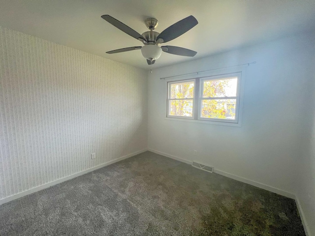 spare room featuring ceiling fan and dark colored carpet