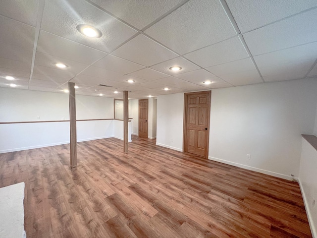 basement featuring hardwood / wood-style floors and a paneled ceiling