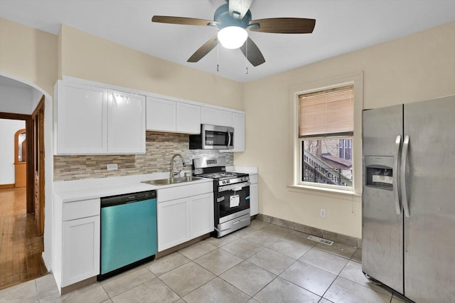 kitchen with white cabinets, sink, ceiling fan, decorative backsplash, and appliances with stainless steel finishes