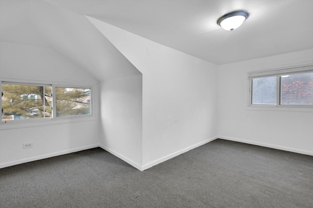 bonus room featuring lofted ceiling and dark colored carpet