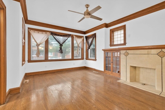 unfurnished living room featuring a fireplace, wood-type flooring, ceiling fan, and ornamental molding