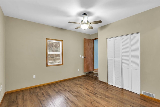 unfurnished bedroom featuring hardwood / wood-style floors, a closet, and ceiling fan