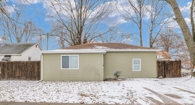 view of snow covered rear of property