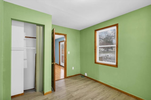 unfurnished bedroom with light wood-type flooring and a closet