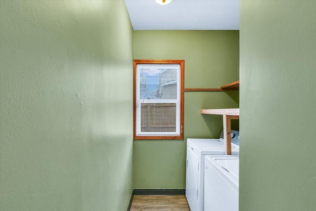 laundry room featuring washing machine and dryer and light hardwood / wood-style flooring