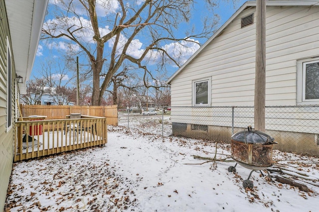 yard layered in snow with a deck and an outdoor fire pit