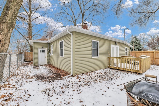 snow covered house featuring a deck