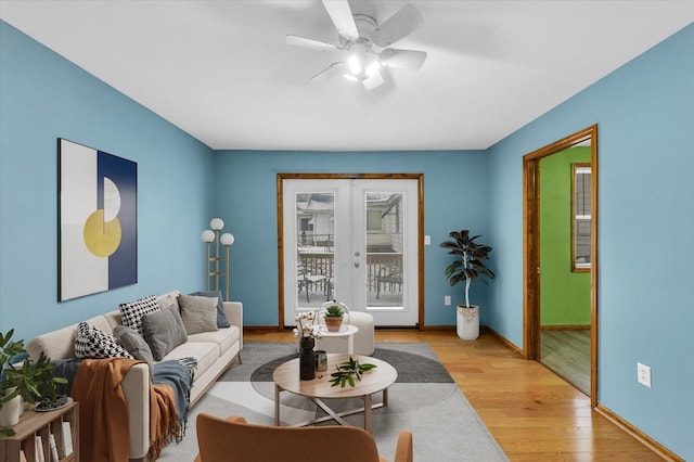 living room featuring a wealth of natural light, french doors, light hardwood / wood-style flooring, and ceiling fan