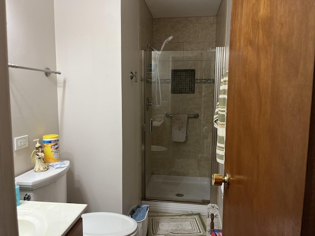 bathroom with toilet, vanity, and walk in shower