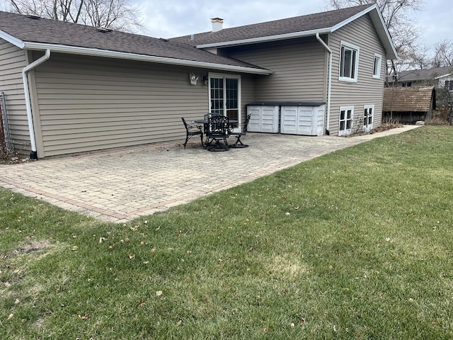 back of house with a yard and a patio