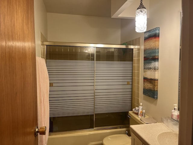 full bathroom with vanity, bath / shower combo with glass door, and toilet