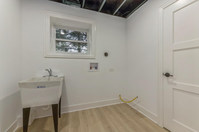 clothes washing area with washer hookup and light wood-type flooring