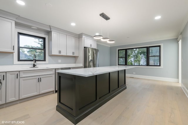 kitchen with light stone counters, sink, white cabinets, and stainless steel refrigerator with ice dispenser