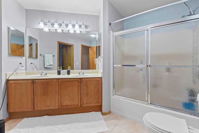 full bathroom with toilet, vanity, tile patterned floors, and bath / shower combo with glass door