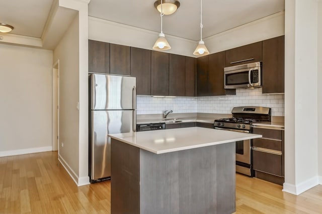 kitchen with dark brown cabinetry, decorative backsplash, light wood-type flooring, and appliances with stainless steel finishes