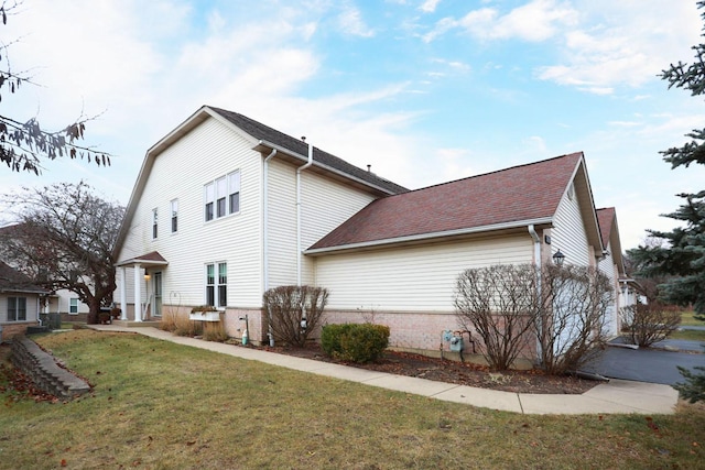 view of side of home with a yard