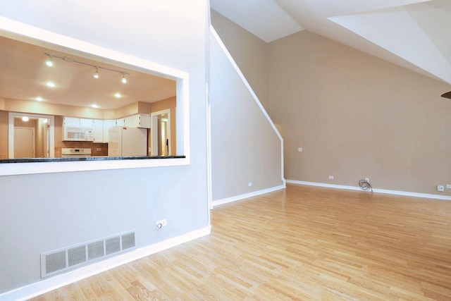 unfurnished living room with rail lighting and light wood-type flooring