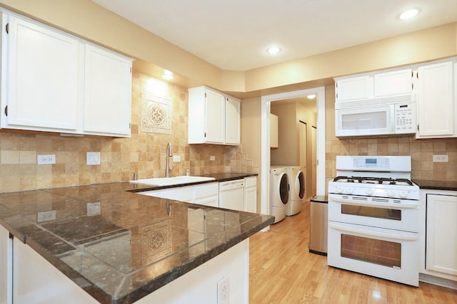 kitchen featuring washer and clothes dryer, white cabinets, white appliances, and sink