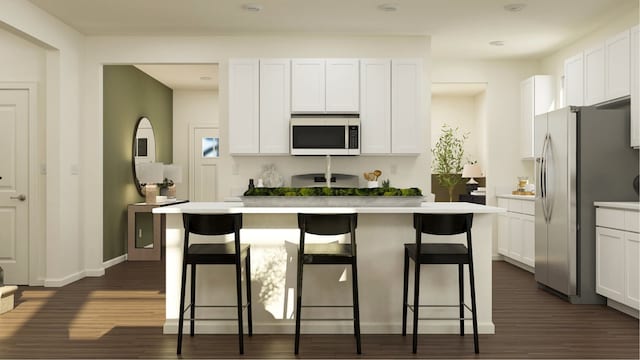 kitchen with white cabinets, a kitchen island with sink, and a breakfast bar area