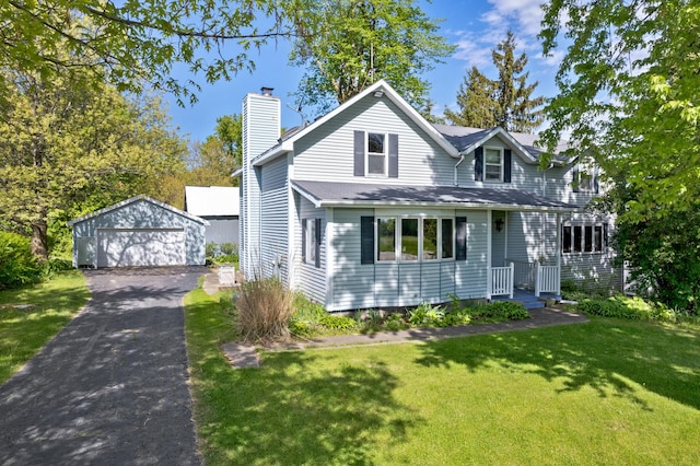 front of property featuring a garage, an outbuilding, and a front lawn