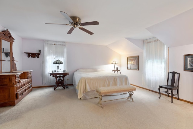 bedroom with ceiling fan, light colored carpet, and vaulted ceiling