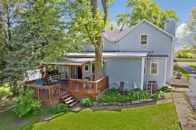 rear view of house featuring central AC, a yard, and a deck