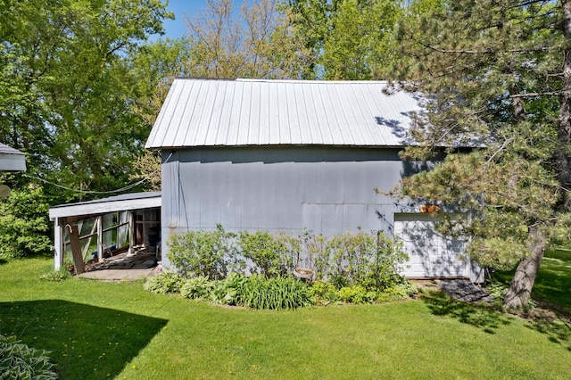 view of side of home featuring a lawn and an outdoor structure