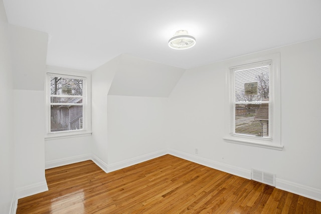 bonus room with light hardwood / wood-style flooring and lofted ceiling