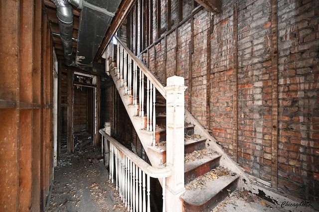 stairs featuring brick wall