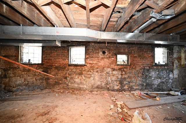 basement with plenty of natural light and brick wall