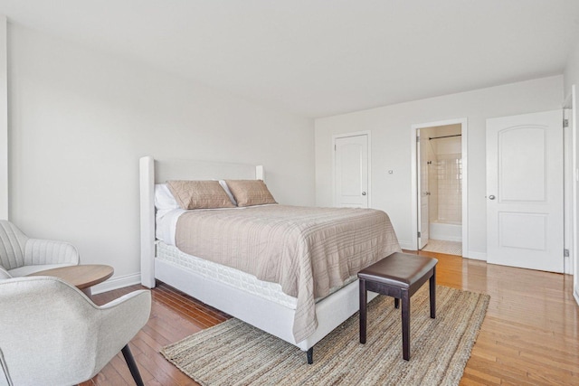 bedroom with wood-type flooring and connected bathroom