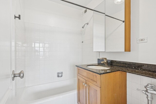 bathroom featuring vanity and tiled shower / bath combo