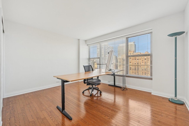 unfurnished office with hardwood / wood-style floors