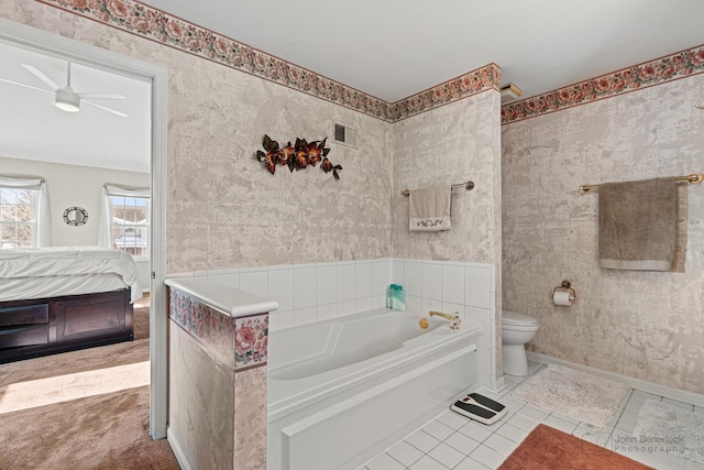 bathroom featuring a tub, ceiling fan, tile patterned flooring, and toilet