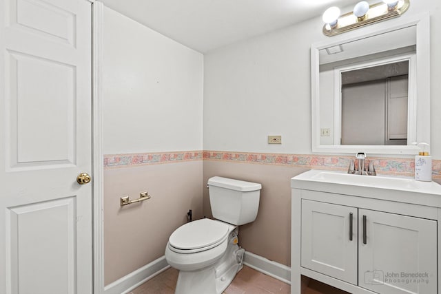 bathroom with tile patterned flooring, vanity, and toilet