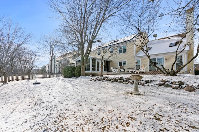 snow covered house with a sunroom